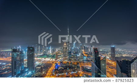 Aerial panorama of tallest towers in Dubai Downtown skyline and highway all night timelapse. Aerial panorama of tallest towers in Dubai Downtown skyline and highway all night timelapse. 87925823