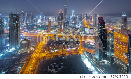 Aerial view of tallest towers in Dubai Downtown skyline and highway night to day timelapse. Aerial view of tallest towers in Dubai Downtown skyline and highway night to day timelapse. 87925923