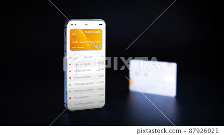 Mobile banking application. Mobile phone with internet online bank app. Credit card on black background. Save money business wallet. 87926021