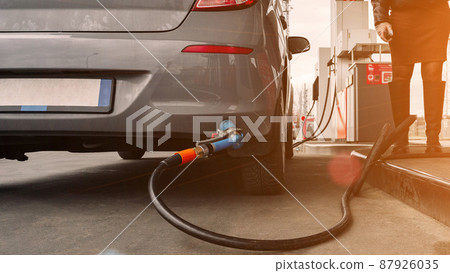 Refueling car. Pump gas at petrol fuel station. Gasoline oil nozzle tank from hand person. Automotive industry or transportation concept. 87926035
