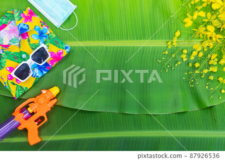 Songkran Festival background with jasmine garland Flowers in a bowl of water, perfume and limestone on a green wet banana leaf background. Songkran Festival background with jasmine garland Flowers in a bowl of water, perfume and limestone on a green wet banana leaf background. 87926536