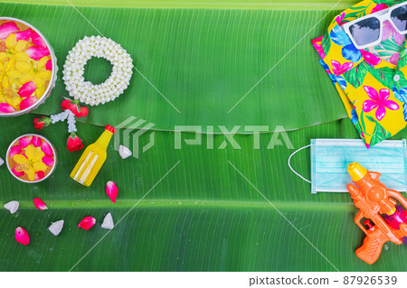 Songkran Festival background with jasmine garland Flowers in a bowl of water, perfume and limestone on a green wet banana leaf background. Songkran Festival background with jasmine garland Flowers in a bowl of water, perfume and limestone on a green wet banana leaf background. 87926539