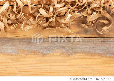 Wood shavings on table background. Wooden shaving at old plank board 87926872
