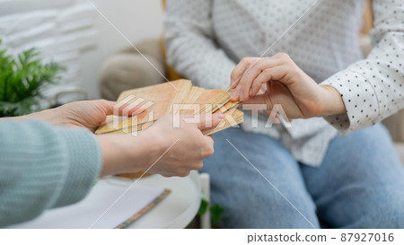 Psychologist uses metaphorical associative cards in a session with a patient. Close-up of female hands. Psychologist uses metaphorical associative cards in a session with a patient. Close-up of female hands. 87927016