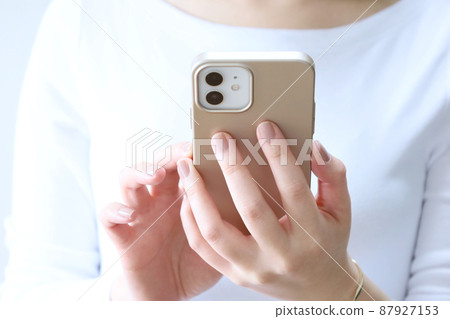 A woman touching a smartphone A woman touching a smartphone 87927153