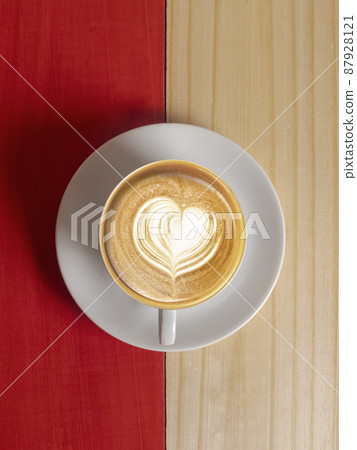 Coffee Mug on Wooden Table. Top view cup of coffee on wooden table. Close up hot coffe in white cup on wood table. Coffee latte art heart shapes in white cup on wood table. Coffee Mug on Wooden Table. Top view cup of coffee on wooden table. Close up hot coffe in white cup on wood table. Coffee latte art heart shapes in white cup on wood table. 87928121