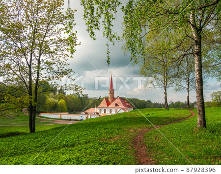 Bright sunny spring view with hiking path to the old white Maltese castle. State Museum Reserve Gatchina. Russia. 87928396