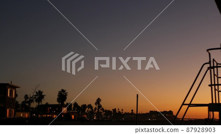 Palm trees silhouettes in twilight sky, California beach, USA. Beachfront houses 87928903