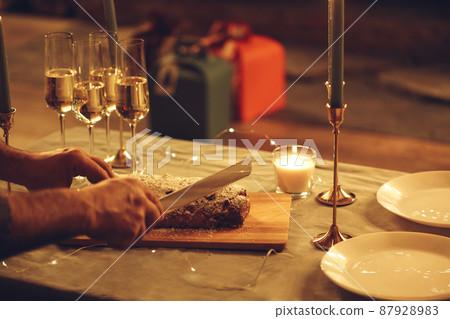 Woman cutting freshly baked homemade pie with knife, celebrating Christmas Eve with friends at home. Woman cutting freshly baked homemade pie with knife, celebrating Christmas Eve with friends at home. 87928983