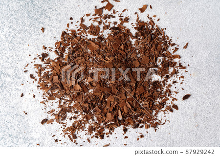 Grated dark chocolate shavings on gray background Grated dark chocolate shavings on gray background 87929242