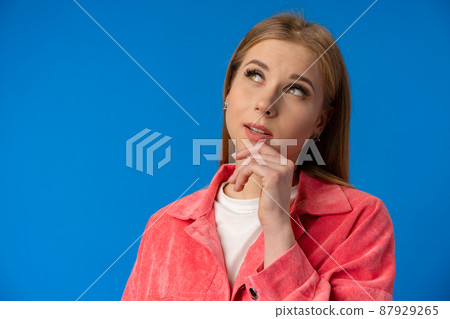 Thoughtful beautiful young woman deep thinking against blue background 87929265