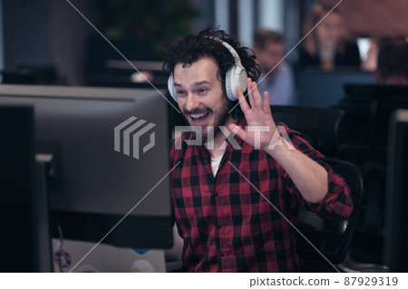 Funny businessman wearing headset having virtual team meeting group call chatting with diverse people in customer support. Video conference call on computer with manager and employees. 87929319