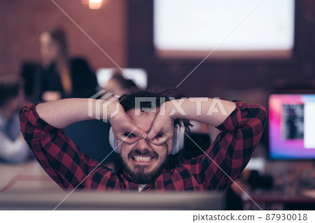 Funny businessman wearing headset having virtual team meeting group call chatting with diverse people in customer support. Video conference call on computer with manager and employees. 87930018