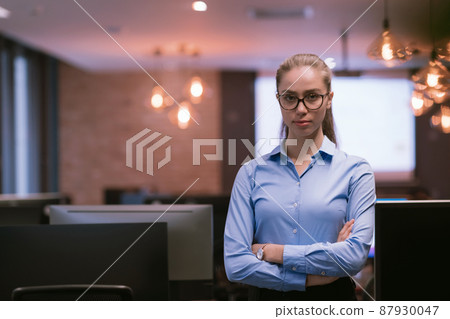 Portrait of freelancer standing in co-working space. Confident businesswoman looking at camera. Portrait of freelancer standing in co-working space. Confident businesswoman looking at camera. 87930047