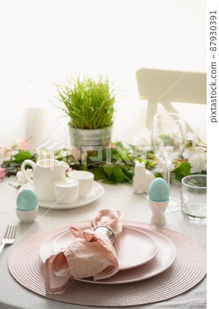 Easter table setting with blue coloful eggs, festive decorations, fresh flowers. Easter table setting with blue coloful eggs, festive decorations, fresh flowers. 87930391