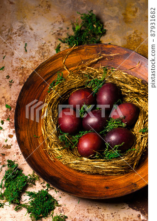 red Easter eggs in a nest of straw 87931682