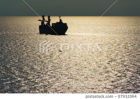 silhouettes of ship at sea, dramatic seascape with sunset sky, bright sunlight reflected from the waves silhouettes of ship at sea, dramatic seascape with sunset sky, bright sunlight reflected from the waves 87932064