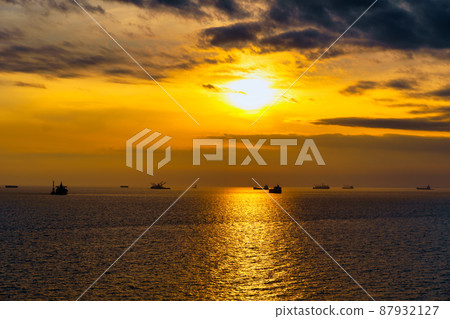 Beautiful sunset in the sea and ships. The sun shines through the clouds and is reflected in the waves Beautiful sunset in the sea and ships. The sun shines through the clouds and is reflected in the waves 87932127