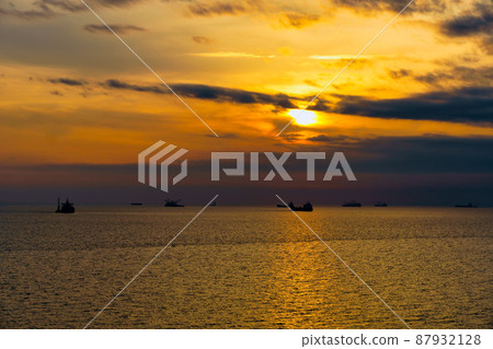Beautiful sunset in the sea and ships. The sun shines through the clouds and is reflected in the waves Beautiful sunset in the sea and ships. The sun shines through the clouds and is reflected in the waves 87932128