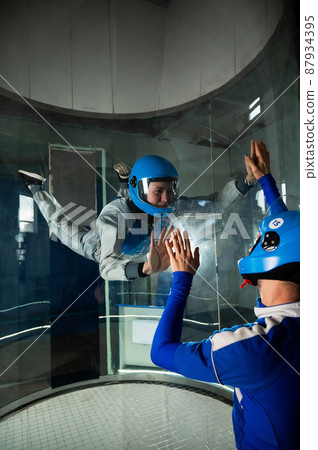 A man trains a woman as an astronaut. Classes on flying in a wind tunnel. A man trains a woman as an astronaut. Classes on flying in a wind tunnel. 87934395