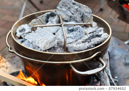 Photo of cooking a Dutch oven with charcoal Photo of cooking a Dutch oven with charcoal 87934682