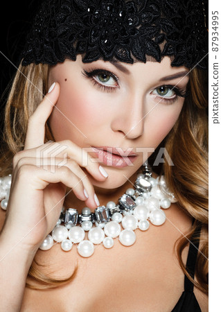 Perfect beauty and jewelry concept. Portrait of beautiful female model wearing ring, necklace and wristband on black background. Young blond woman shows glamorous finery 87934995