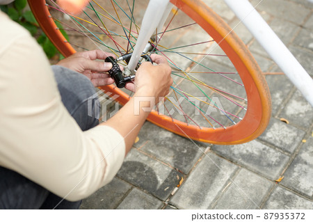 Student Securing Parked Bicycle 87935372