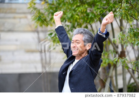 A senior man who is happy with a smile after doing a banzai A senior man who is happy with a smile after doing a banzai 87937082