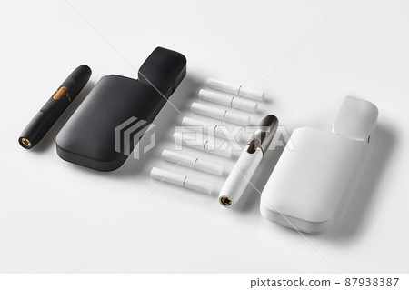 New generation black and white, two electronic cigarettes and two open batteries, seven heatsticks isolated on white. Heating tobacco system. Close up New generation black and white, two electronic cigarettes and two open batteries, seven heatsticks isolated on white. Heating tobacco system. Close up 87938387