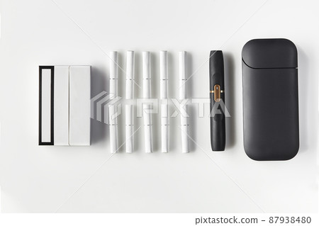 New generation black electronic cigarette and battery, pack and ten heatsticks isolated on white. New technology. Heating tobacco system. Close up New generation black electronic cigarette and battery, pack and ten heatsticks isolated on white. New technology. Heating tobacco system. Close up 87938480