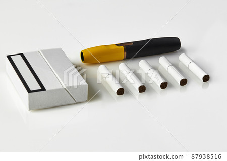 New generation black and yellow electronic cigarette, pack and five heatsticks, isolated on white. New technology. Advertising area. Close up New generation black and yellow electronic cigarette, pack and five heatsticks, isolated on white. New technology. Advertising area. Close up 87938516