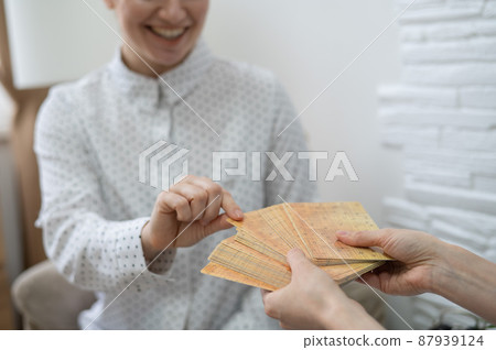 Psychologist uses metaphorical associative cards in a session with a patient. Close-up of female hands. 87939124