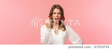 Close-up portrait of pissed-off bothered and fed up blond girlfriend arguing with boyfriend, showing him finger without ring as willing finally get married, standing upset pink background Close-up portrait of pissed-off bothered and fed up blond girlfriend arguing with boyfriend, showing him finger without ring as willing finally get married, standing upset pink background 87939784