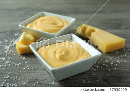 Bowls with cheese sauce, cheese and salt on gray textured table Bowls with cheese sauce, cheese and salt on gray textured table 87939939