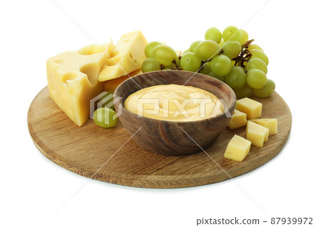 Board with cheese sauce, grape and cheese isolated on white background 87939972