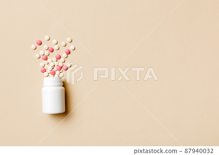 Multicolored pills and capsules in plastic bottle on Colored background, copy space. Many different various medicine tablets and pills, vitamin and nutritional supplements concept Multicolored pills and capsules in plastic bottle on Colored background, copy space. Many different various medicine tablets and pills, vitamin and nutritional supplements concept 87940032