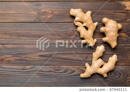 Finely dry Ginger powder in bowl with green leaves isolated on colored background. top view flat lay 87940111