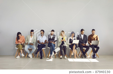 Modern way to communicate. Woman in row with people who came for interview and are busy reading resumes or surfing internet. Concept of human resources, employment, customers and electronic devices. Modern way to communicate. Woman in row with people who came for interview and are busy reading resumes or surfing internet. Concept of human resources, employment, customers and electronic devices. 87940130