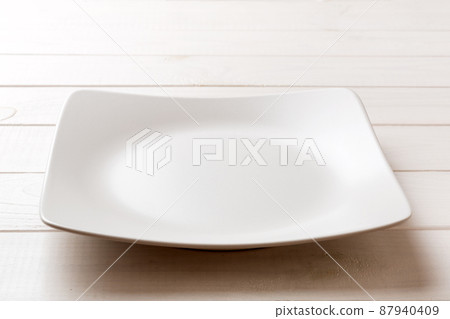 Perspective view of empty square plate on wooden background. Empty space for your design Perspective view of empty square plate on wooden background. Empty space for your design 87940409