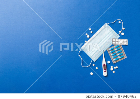Protective face masks or surgical masks, medicine pills and thermometer on table background. Coronavirus disease. Corona virus concept. Space for text 87940462