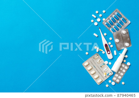 Protective face masks or surgical masks, medicine pills and thermometer on table background. Coronavirus disease. Corona virus concept. Space for text Protective face masks or surgical masks, medicine pills and thermometer on table background. Coronavirus disease. Corona virus concept. Space for text 87940465