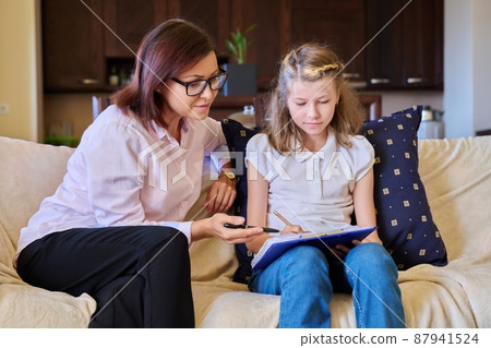 Woman social worker talking to baby girl, meeting session at home on sofa Woman social worker talking to baby girl, meeting session at home on sofa 87941524