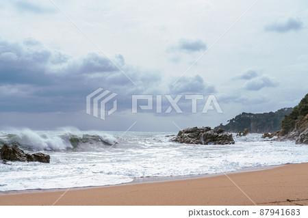 High Tides Coming on to the Rocky Shores of Costa Brava in Spain, cloudy weather 87941683