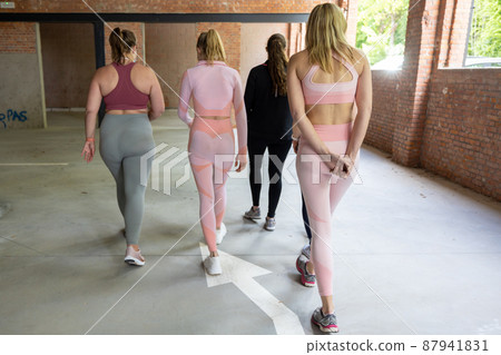 Smiling group of fit female friends of diverse body types in sportswear walking away together after Smiling group of fit female friends of diverse body types in sportswear walking away together after 87941831
