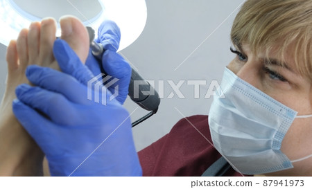 Patient on medical pedicure procedure, visiting podiatrist.Professional hardware pedicure using 87941973