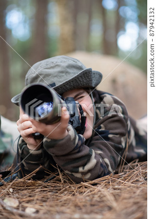 Happy boy taking pictures in forest Happy boy taking pictures in forest 87942132