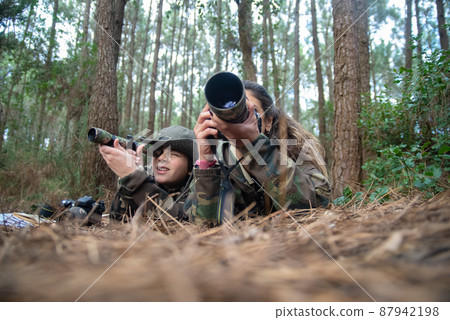 Focused mother and son taking pictures in forest 87942198