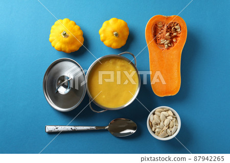 Concept of tasty food with pumpkin soup on blue background Concept of tasty food with pumpkin soup on blue background 87942265