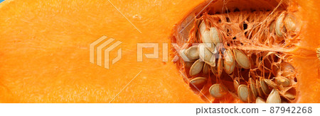 Half of raw pumpkin on blue background Half of raw pumpkin on blue background 87942268