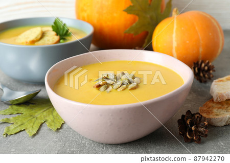 Concept of tasty food with pumpkin soup on gray textured table Concept of tasty food with pumpkin soup on gray textured table 87942270
